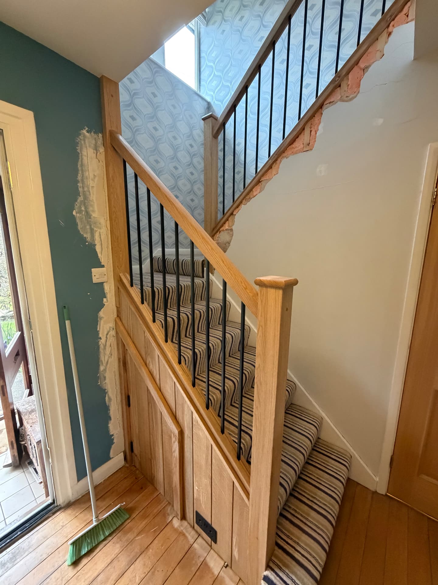 Staircase with oak handrail, black spindles and understairs storage