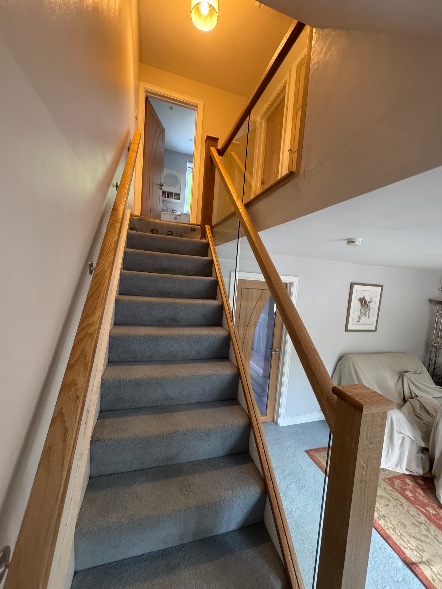 Staircase with oak handrail and frameless glass balustrade